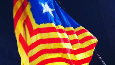 En röd- och gulrandig flagga. På ena sidan är det en blå triangel med en vit stjärna på.