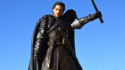 En karaktär från Game of thrones står med höjt svärd och ser bestämd ut.