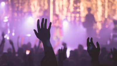 Människor sträcker upp händerna på en koncert