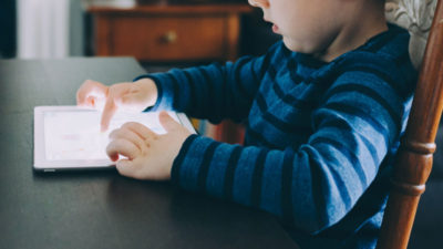 Ett barn som sitter med en surfplatta.