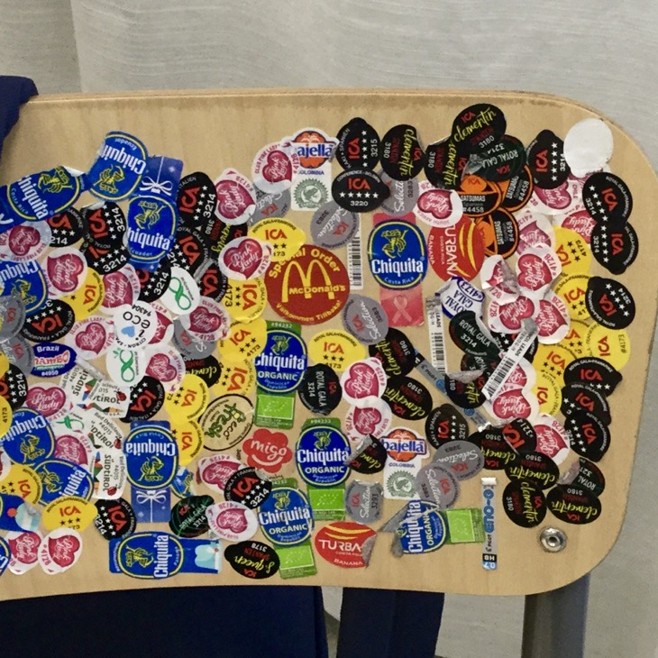 Ryggen på en stol är täckt av klistermärken från frukter.