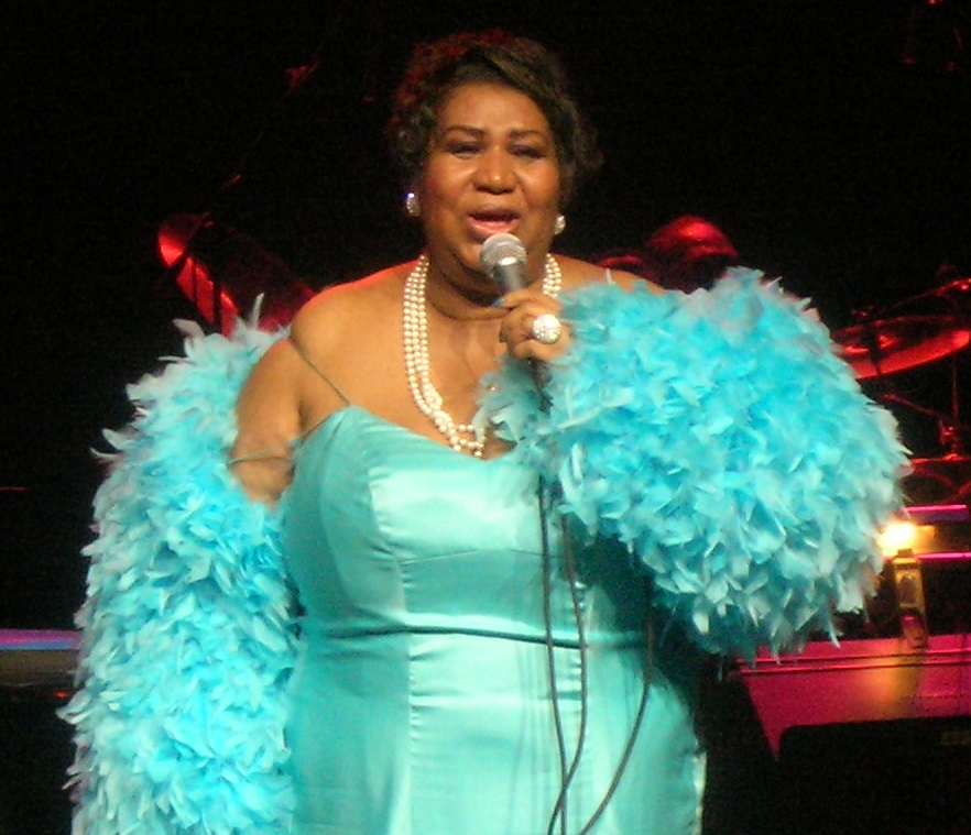 Aretha Franklin i en turkod klänning på scen.
