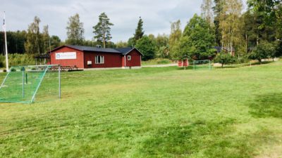 Bild på gräsmattan på en fotbollsplan utan linjer.