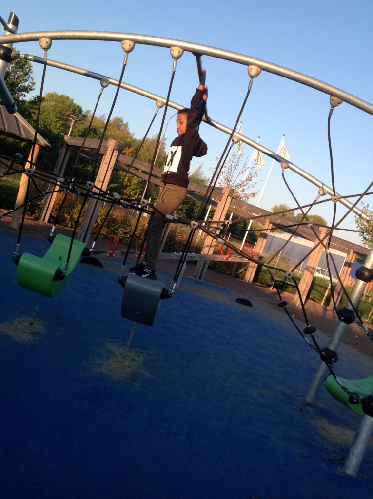 Ett barn hänger i en klätterställning.