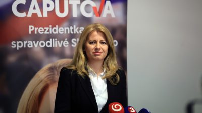 Bild på Zuzana Caputová som står framför flera mikrofoner redo att bli intervjuad av journalister.