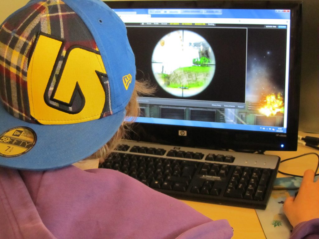 Bild på en person bakifrån som sitter och spelar datorspel.
