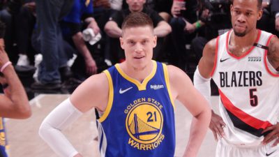 Jonas Jerebko står med händerna på höfterna och väntar på att bollen ska sättas igång i matchen mot Portland. Precis bakom honom står en av motståndarna och i bakgrunden syns publiken på läktarna.