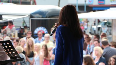 En person som står på scen framför en publik