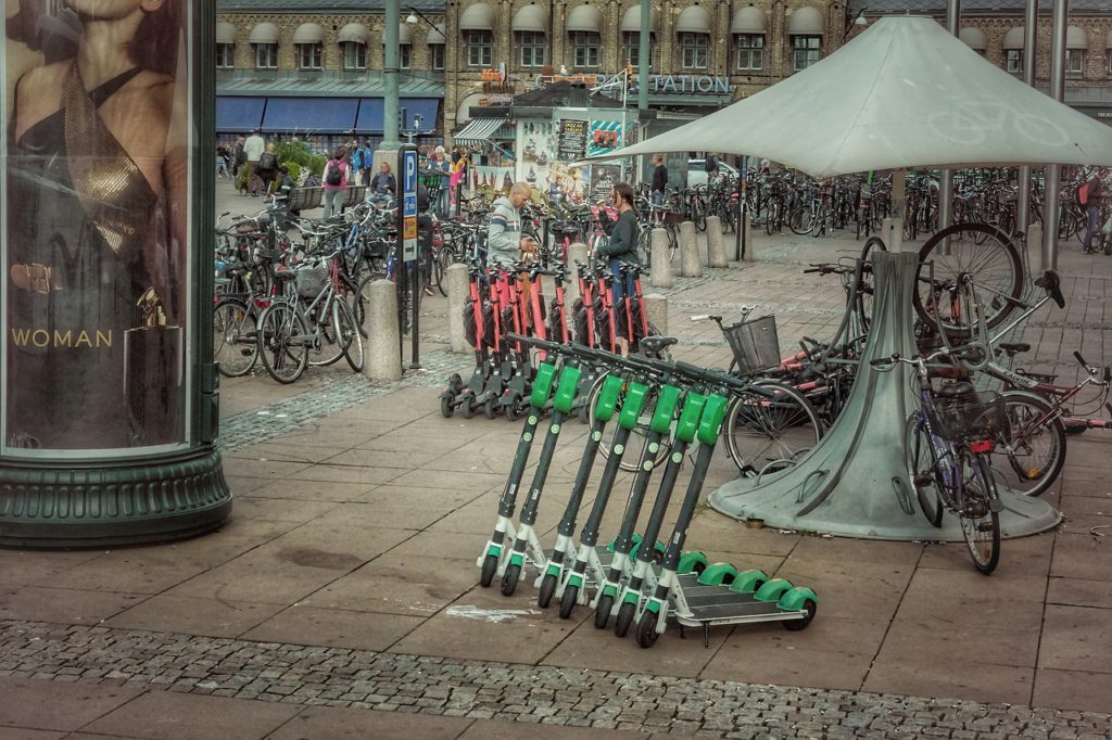 Gröna och röda elsparkcyklar som står på rad