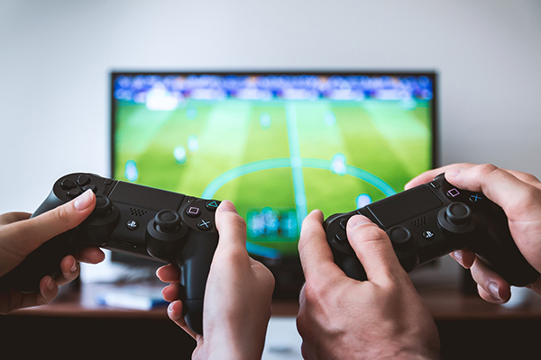 Foto på två personer som spelar tv-spel.