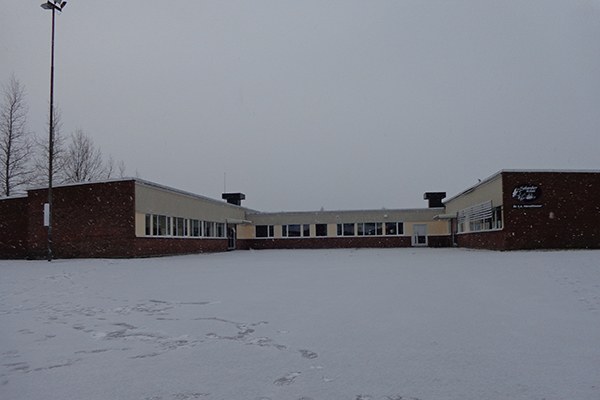 Foto på en röd skolbyggnad.
