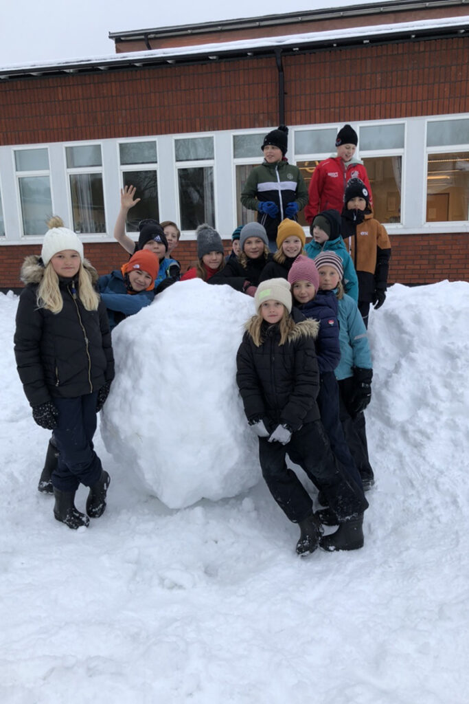 Klassen framför en stor snöboll.
